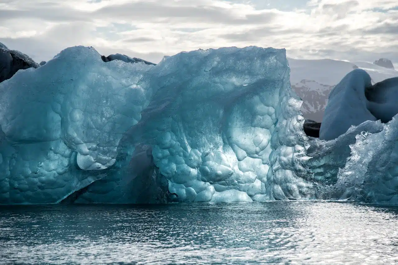 Majestic icebergs float in the serene waters of Iceland, showcasing stunning icy formations.