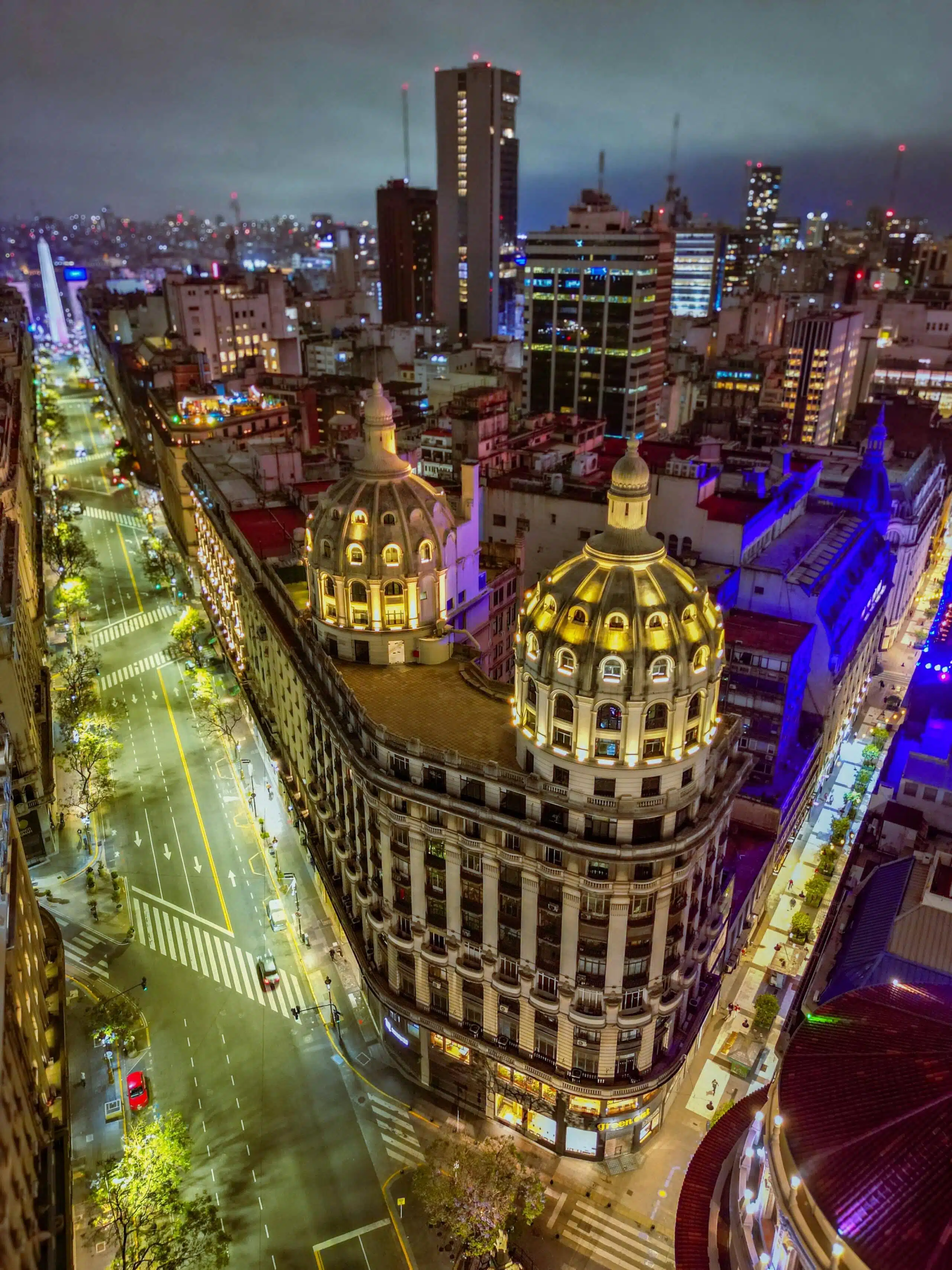 Stunning aerial night view of bustling Buenos Aires cityscape featuring iconic architecture and vibrant streets.